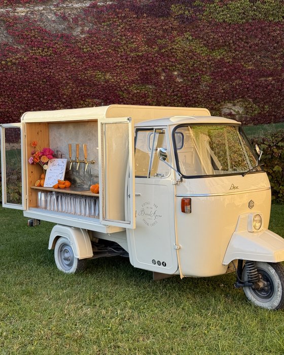 A vintage Ape van set up as a bar on the lawn